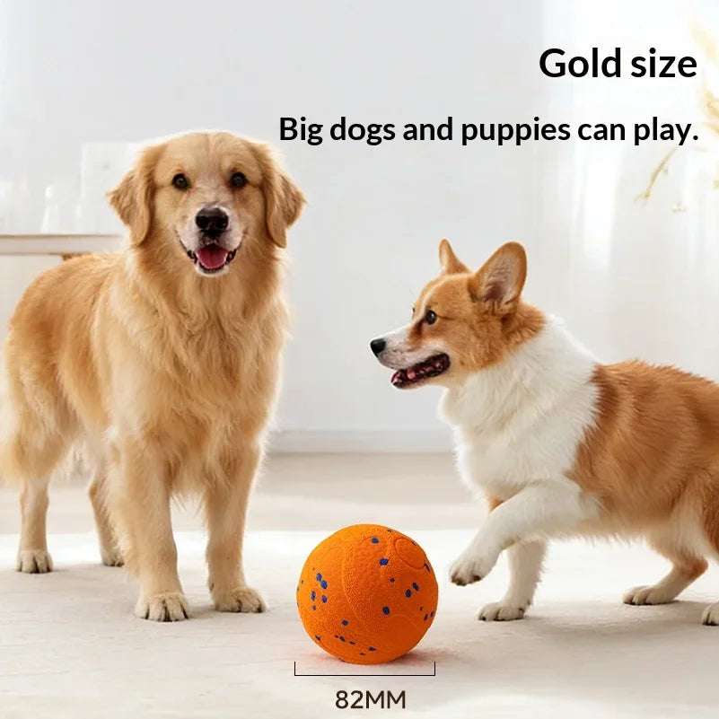 A golden retriever dog is playing with an orange indestructible smart chew ball on a light floor.