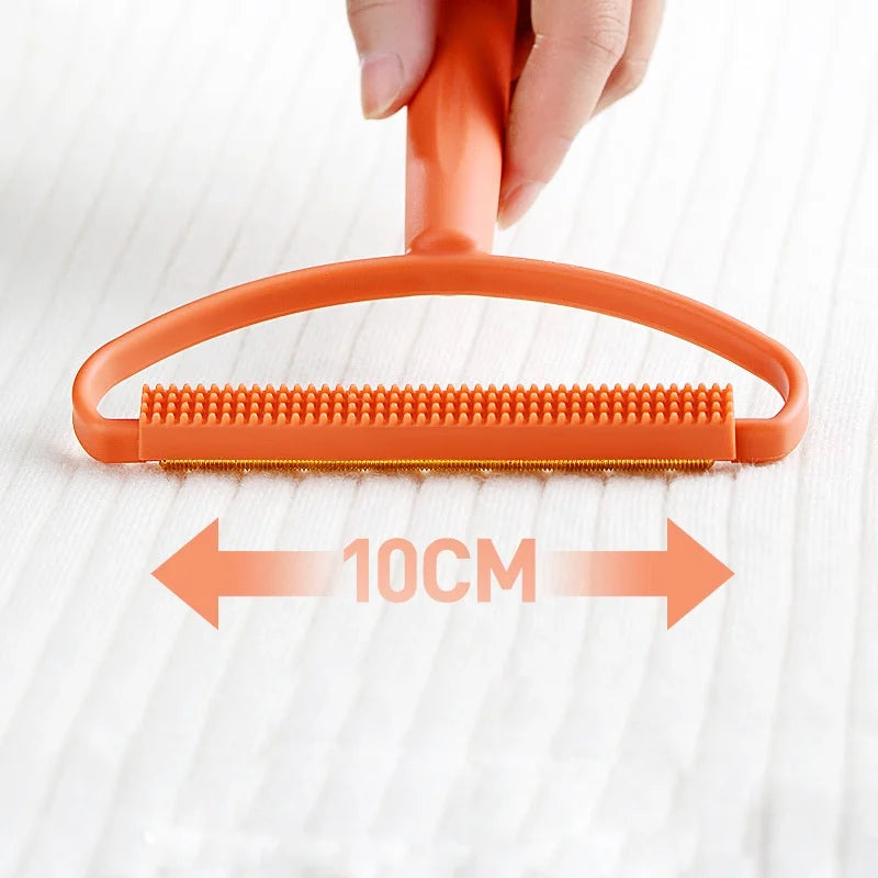 Orangefarbenes manuelles Fasenentfernerwerkzeug mit einer 10 cm breiten Bürste wird von einer Hand auf einer weißen Oberfläch