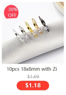 A set of 10 antique silver wing charms with zip attachments displayed on a white surface.