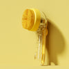 Une brosse de bain en silicone jaune pour le toilettage des animaux, sur fond beige.