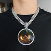 A silver-toned chain necklace with a round pendant featuring a photo of a couple sitting by a campfire.