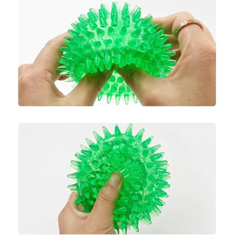 A hand holds a bright green, durable spiky squeaky dog ball designed for teeth cleaning and play.