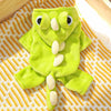 A bright lime green fleece dog hoodie with large animal ears lying on a woven fabric background.