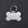 Silver bone-shaped dog ID tag with a circular keyring against a dark background.