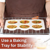 A baking tray holds multiple non-stick silicone egg molds for breakfast sandwiches and baking.