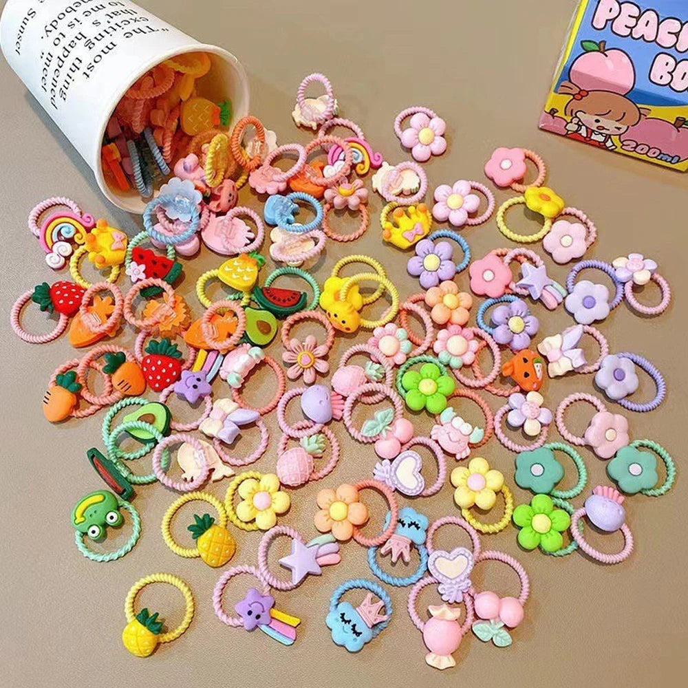 Eine große Packung bunter Cartoon-Haargummis für Mädchen in verschiedenen Formen und Farben.