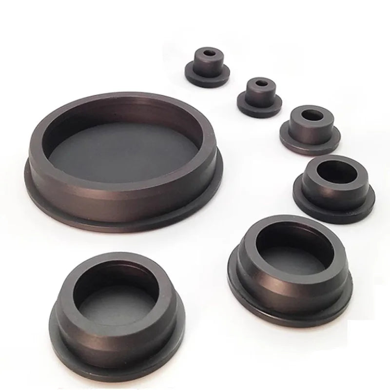 A set of dark silicone rubber hole plugs and rings of various sizes displayed on a white background.