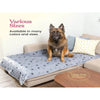 A fluffy brown dog is sitting on a gray sofa with a blue patterned pad, labeled as a large sofa protector.