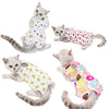 Three cats wearing comfortable recovery vests, showing different styles and colors.