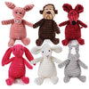 Una colección de diversos juguetes de perro de peluche en colores rosa, marrón, rojo y gris.