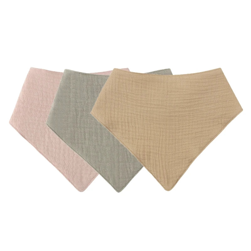 A pack of three soft cotton baby bibs in pink, sage green, and beige.
