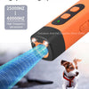 An orange ultrasonic dog repellent device emitting a blue sound wave towards a dog.