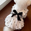White pet dress with black polka dots and a black bow, featuring a leash ring detail.