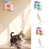 Eine tabbyartige Katze spielt mit einem automatischen elektrischen Spielzeug mit rosa und blauer Mechanik.