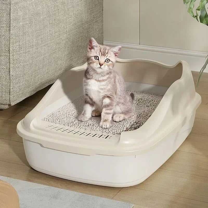 A fluffy gray kitten sits inside a white high-sided cat litter box with an anti-splash design.
