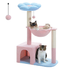 A pink and blue flower-shaped cat tree with a sisal hammock and a fluffy cat resting on the platform.