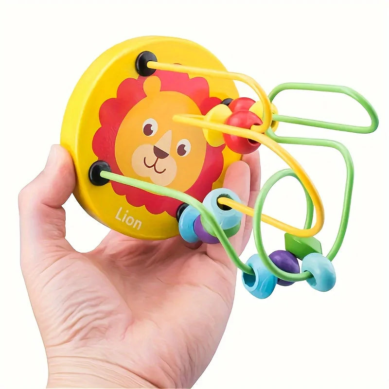 Eine Hand hält ein gelbes, lelionförmiges Puzzlespielzeug mit grünen und lila Ringen für ein Naturfunde-Spiel.