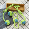 Green rope ball dog toys with blue accents displayed on a wooden tray.