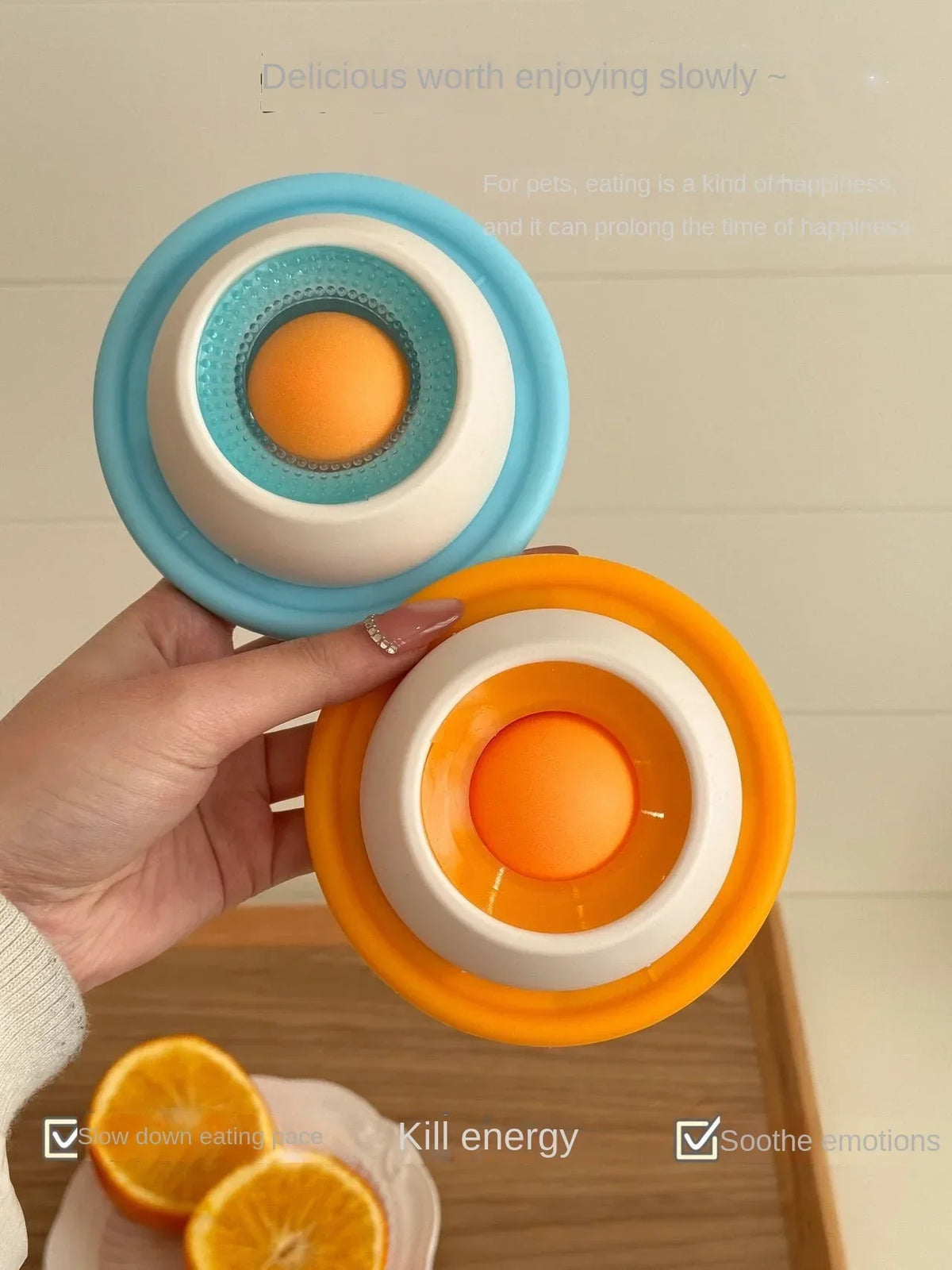 Eine Hand hält ein orange interaktives Tier-Lickspielzeug mit konzentrischen Ringen, das Emotionen beruhigt.