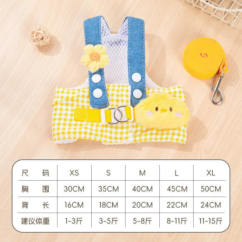 A yellow and blue cartoon dog harness vest with a yellow leash is displayed on a wooden surface.