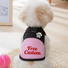 Arnés transpirable de malla rosa y negro para mascotas con diseño de huella, para un perro blanco.