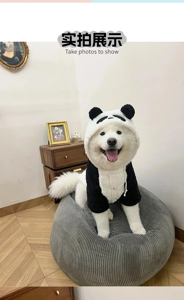A white and black panda-themed fleece dog coat is sitting on a gray fabric object.