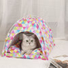 A cozy pet tent bed for cats made of colorful fabric, resting on a white surface.