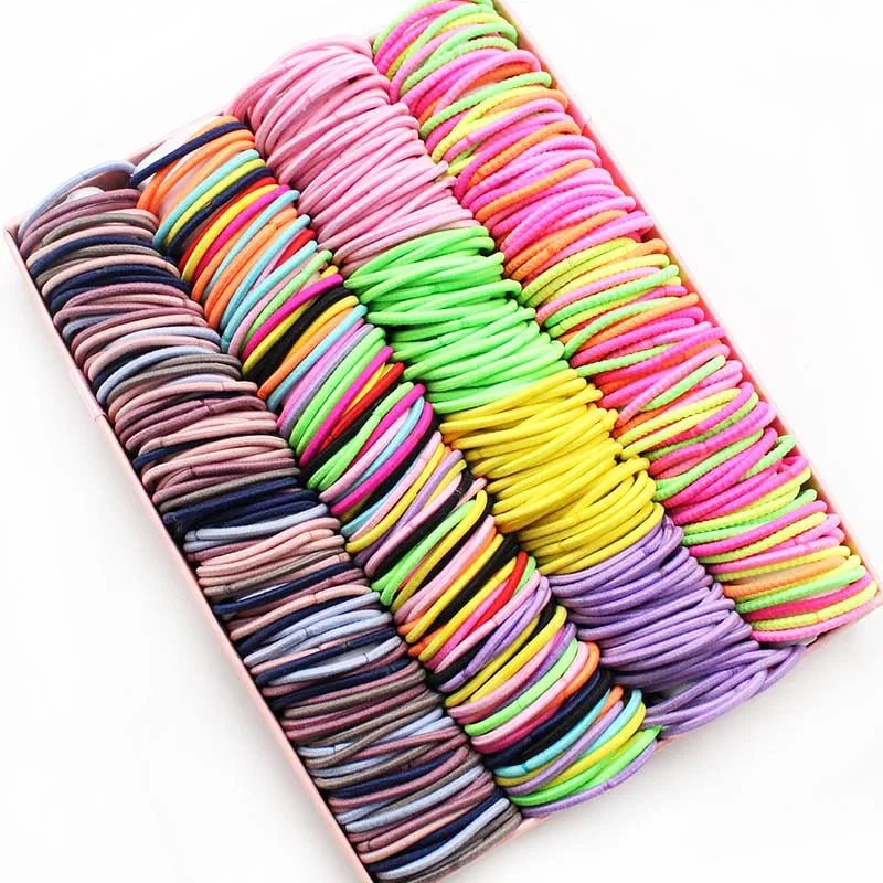 A colorful display of elastic hair bands in various shades of pink, orange, yellow, and purple.