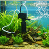 A black 3-in-1 aquarium filter pump is shown with tubing, circulating water and aeration over green aquatic plants.