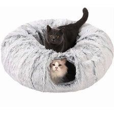 A black cat is peeking out of a fluffy gray plush tunnel bed for a cozy hideaway.