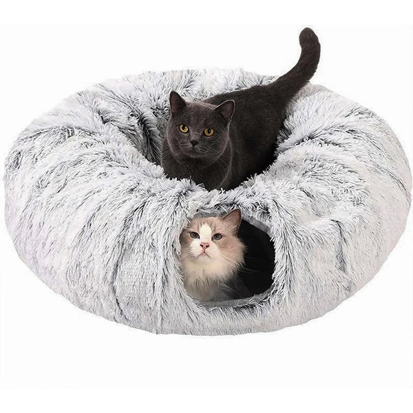 A black cat is peeking out of a fluffy gray plush tunnel bed for a cozy hideaway.
