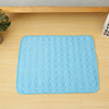 A light blue, quilted cooling mat designed for pet beds, placed on a wooden surface.