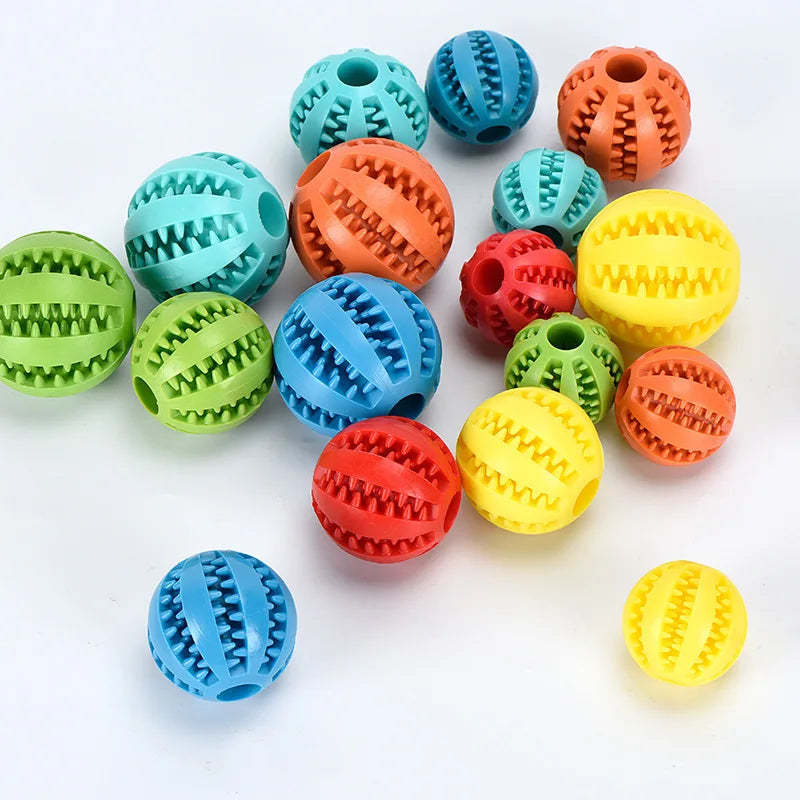 A collection of colorful, textured rubber balls in various shades of green, blue, orange, and yellow for dog treats.