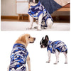 Un chien en noir et blanc portant une combinaison de récupération de l'animal de camouflage bleu et gris.
