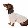 A brown and black dog wearing a light gray cozy winter sweater.