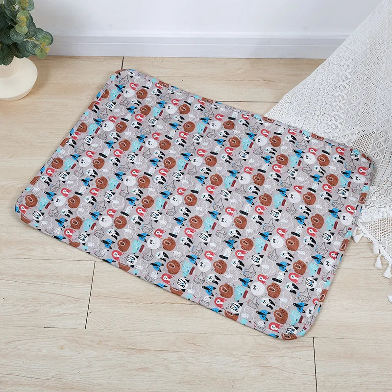 A rectangular washable pet training mat for dogs with a patterned design lying on a light wooden floor.