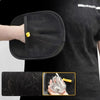 Eine Hand hält einen schwarzen Tierhaarentfernungs-Grooming-Handschuh, der die Textur des Handschuhs und etwas Tierhaar zeigt