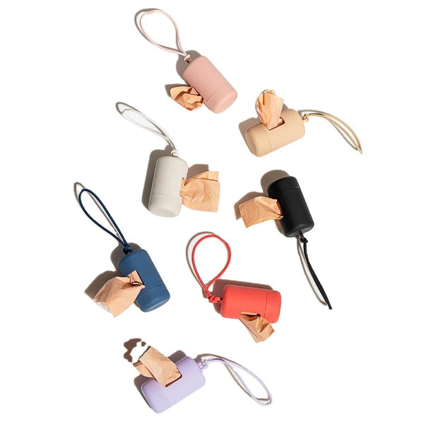 A collection of pink and beige portable dog poop bag dispensers with attached bags.