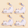 A set of four white cat pendant charms with gold accents and blue details for jewelry making