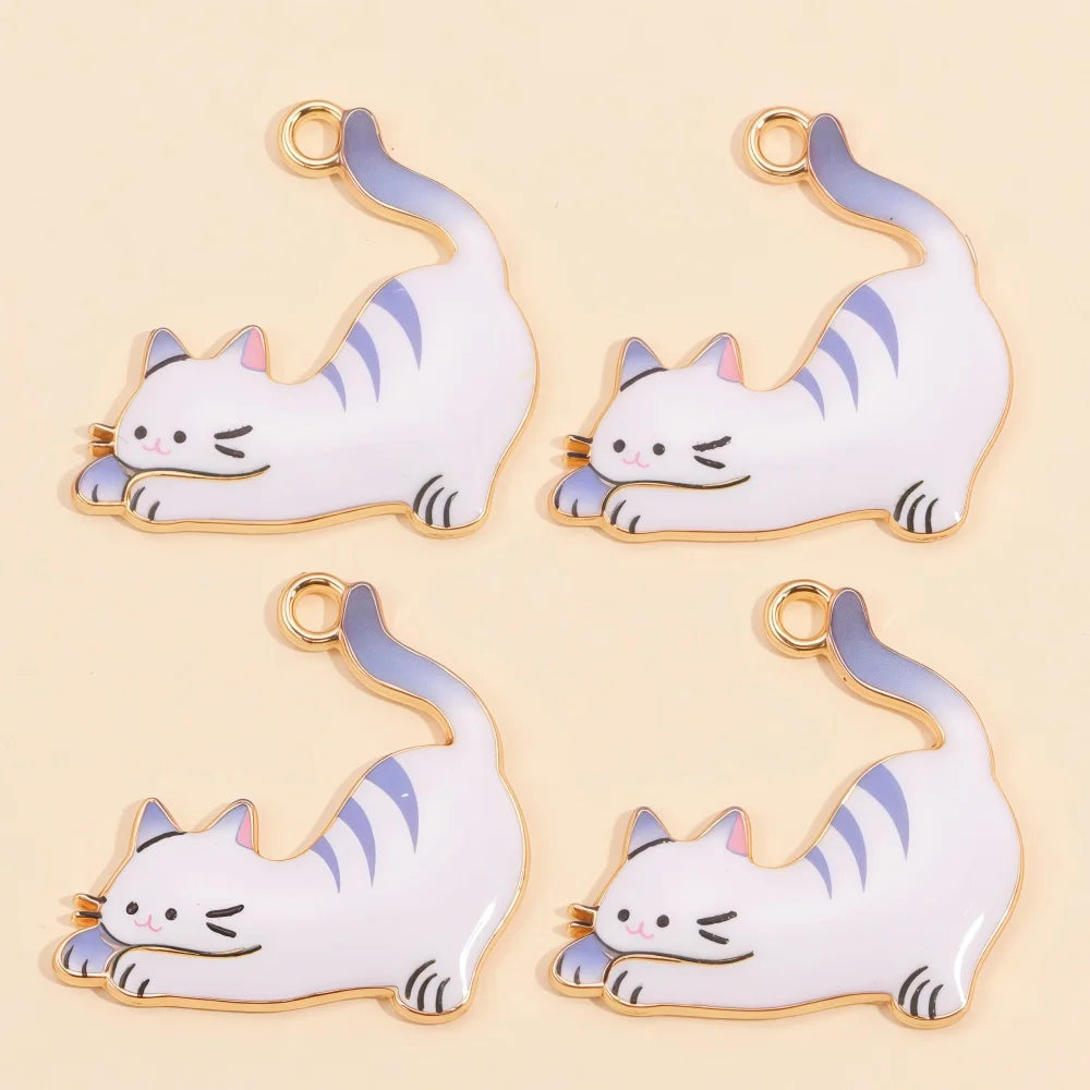 A set of four white cat pendant charms with gold accents and blue details for jewelry making