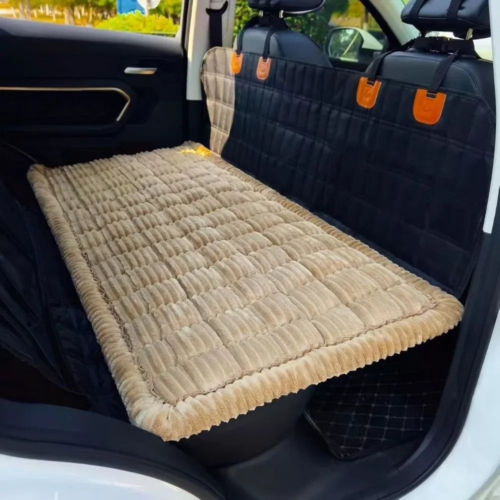 A plaid flannel pet seat protector and car mat placed in the back seat of a vehicle.