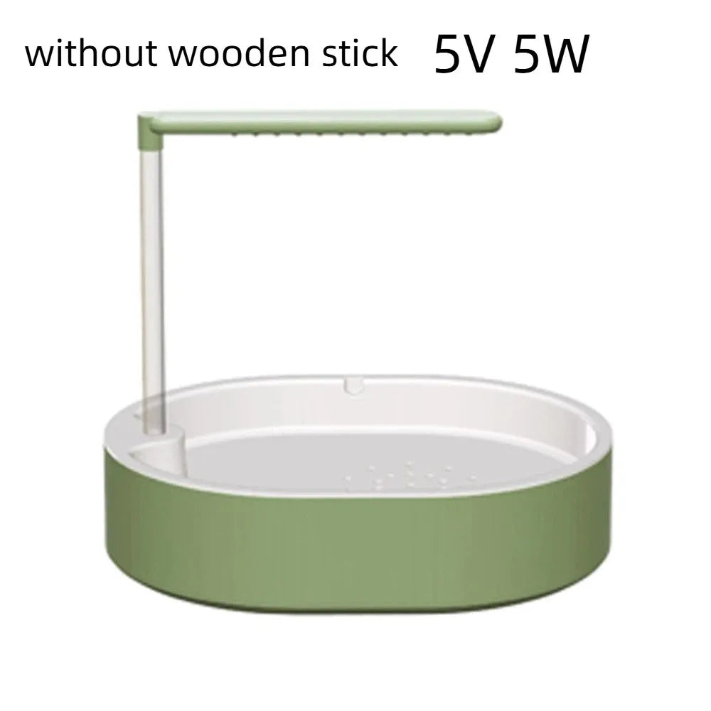 A light green automatic bird bathtub with a resting stick and a circular base.