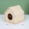 A natural wooden hamster house with a pitched roof and an entrance hole, shown from above.