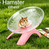 Ein kleiner brauner Hamster rennt in einer klaren Plastikrad auf einem rosa Ständer im Freien.
