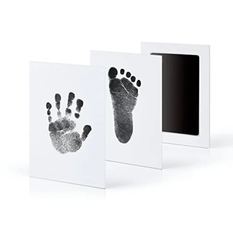 A set of three framed prints showing handprints and footprints on white paper.