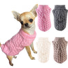 Un petit chien portant un pull tricoté rose, entouré de divers tons de pulls pour chiens tricotés rose et gris.