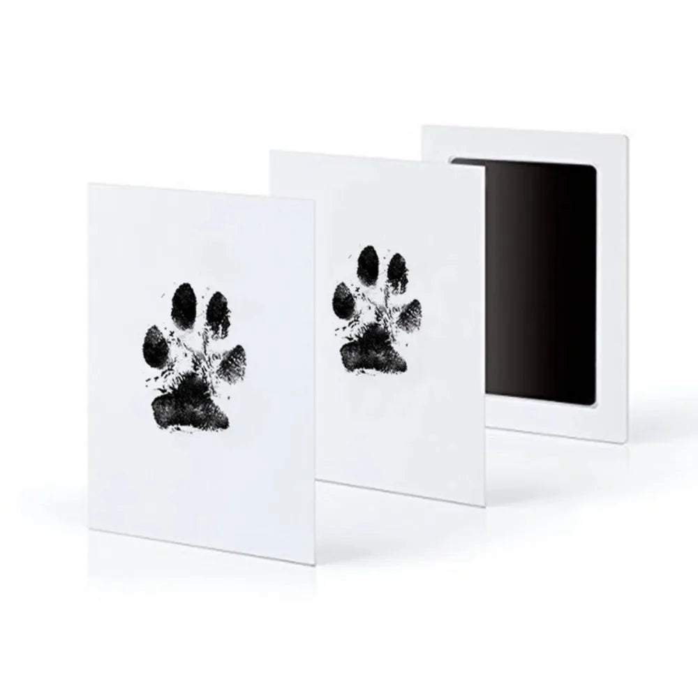 A set of three white framed prints featuring black paw prints for pet keepsake memories.