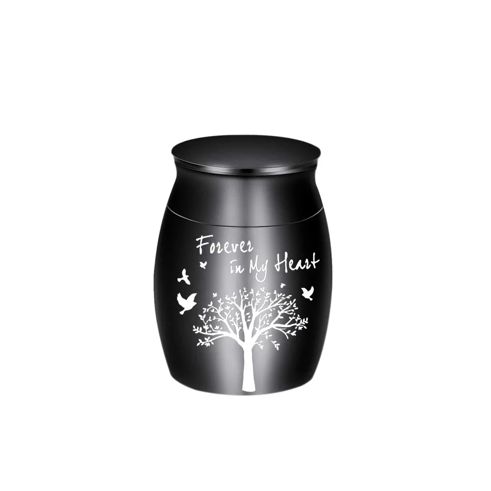 Urne souvenir en aluminium noir en forme d'arbre avec de petits oiseaux volant de ses branches.