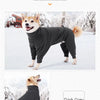 A dark grey fleece jumpsuit for a dog standing outdoors in the snow.