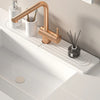 A brass faucet is shown on a white countertop next to a soap dispenser and a mat.